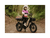 A woman sitting on a black RadRunner Plus electric cargo utility bike wearing a white helmet, pink jacket and grey pants.