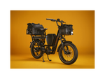 The right angle of a green RadRunner Max electric cargo utility bike with front and rear baskets, a center storage console, range extender, and an illuminated headlight.
