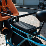 RadWagon 5 Deckpad installed on a blue RadWagon 5 electric cargo bike, with an orange thule yepp chilld seat and a caboose installed.