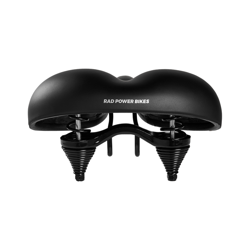 A close-up view of the rear of a matte black Enhanced Comfort Saddle, illustrating the cushion of the saddle and the springs mounted underneath it