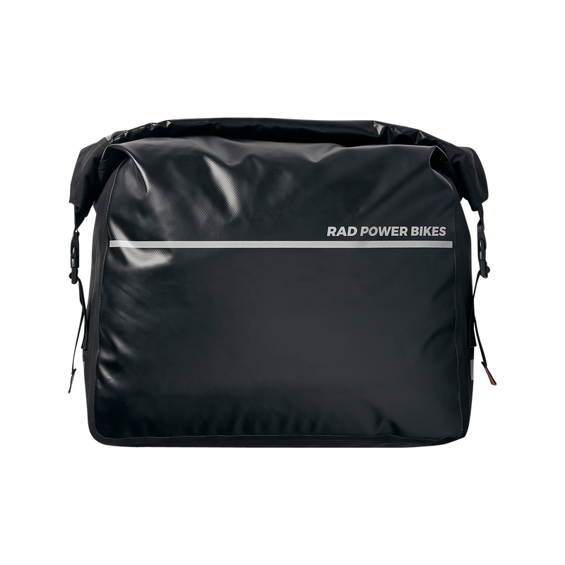 Close up view of a black Ballard Cargo Bag's front side. The top is rolled closed with carrying handle tight across the bag. The front features a silver reflective strip.