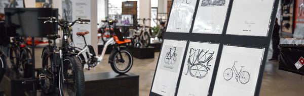 Art provided by 88bikes on display in Rad Power Bikes' showroom next to electric bikes.