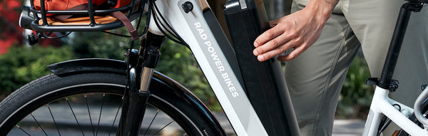 A man's hand removes an electric bike battery from his RadCity 5 Plus.
