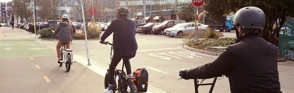 A trio of riders take their electric bikes down a bike lane.