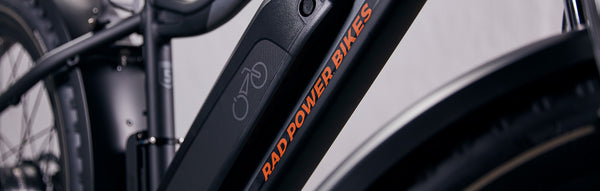 Close-up photo of a black Rad Power Bike ebike, showing the center frame and partial rear tire.