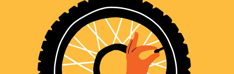 An illustration of a black bike tire on a yellow background. An illustrated hand releases pressure from the valve.
