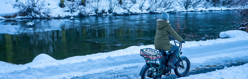 A woman rides her RadRunner electric utility bike in the snow.