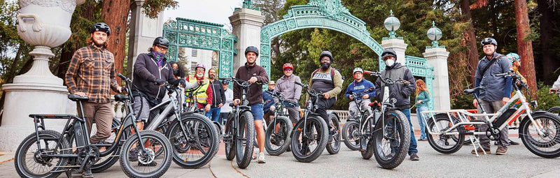 Group of individuals pose with a smile in front of their Rad Power Bike ebikes.