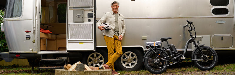 Man stands in front of trailer with a folding ebike.