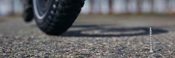 A close-up of an electric bike wheel approaching a menacing looking screw.