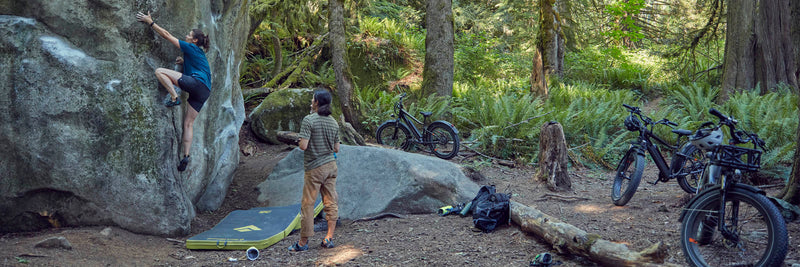 A group of friends rock climb while alongside the RadRover 6 Plus.