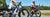 Two women ride their RadRover 6 Plus electric bikes by a farm.