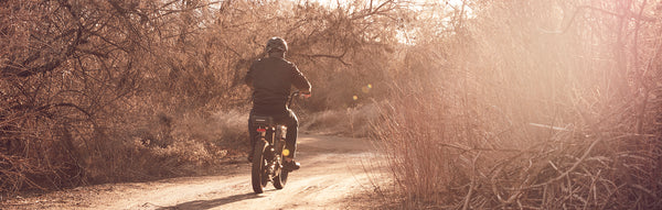 A man rides a RadRunner down a dirt trail.