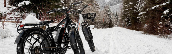 Two Rad Power Bikes ebikes sit on a snowy road.