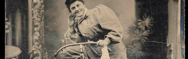 A woman poses with her bike in an 1890 print.