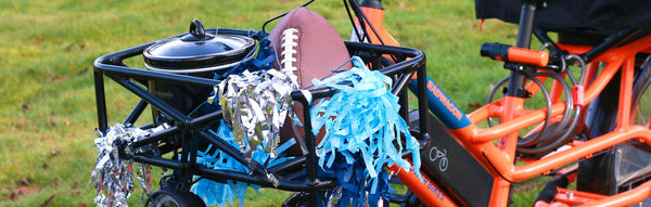 Crockpot and football are carried in an ebike's basket.