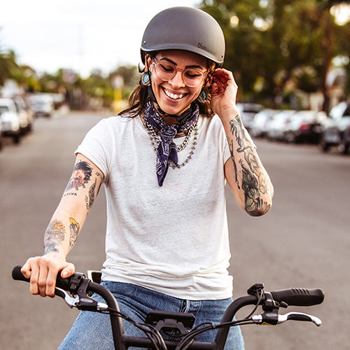 Smiling person in a helmet on an electric bike
