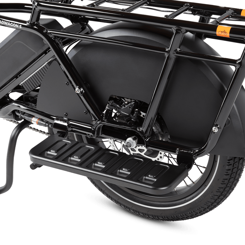 RadWagon Running Boards shown installed on the left side of a RadWagon 5 electric cargo bike. Cast aluminum foot boards that attach to the ebike and allow a passenger to rest their feet. 