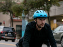 Man riding a bike wearing a Bern Major MIPS helmet in cyan
