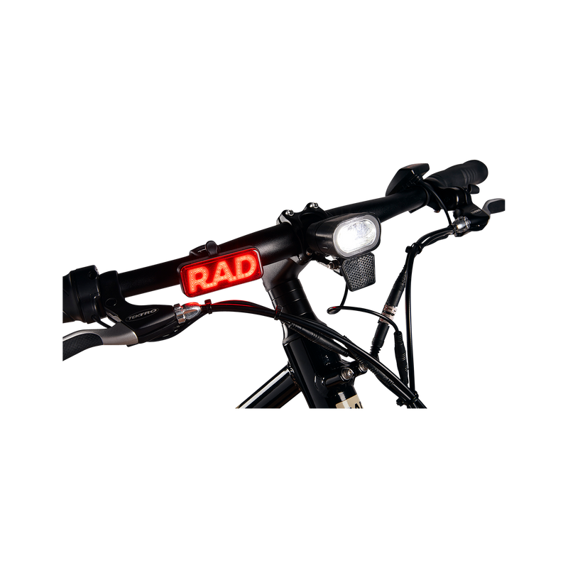 Close up photo of Rad Power Bikes Rad logo taillight mounted on the handlebars of a Rad Mission electric bike.