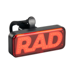 Close up picture of Rad Power Bikes Rad logo taillight not on a bike where you can see part of the mounting strap.