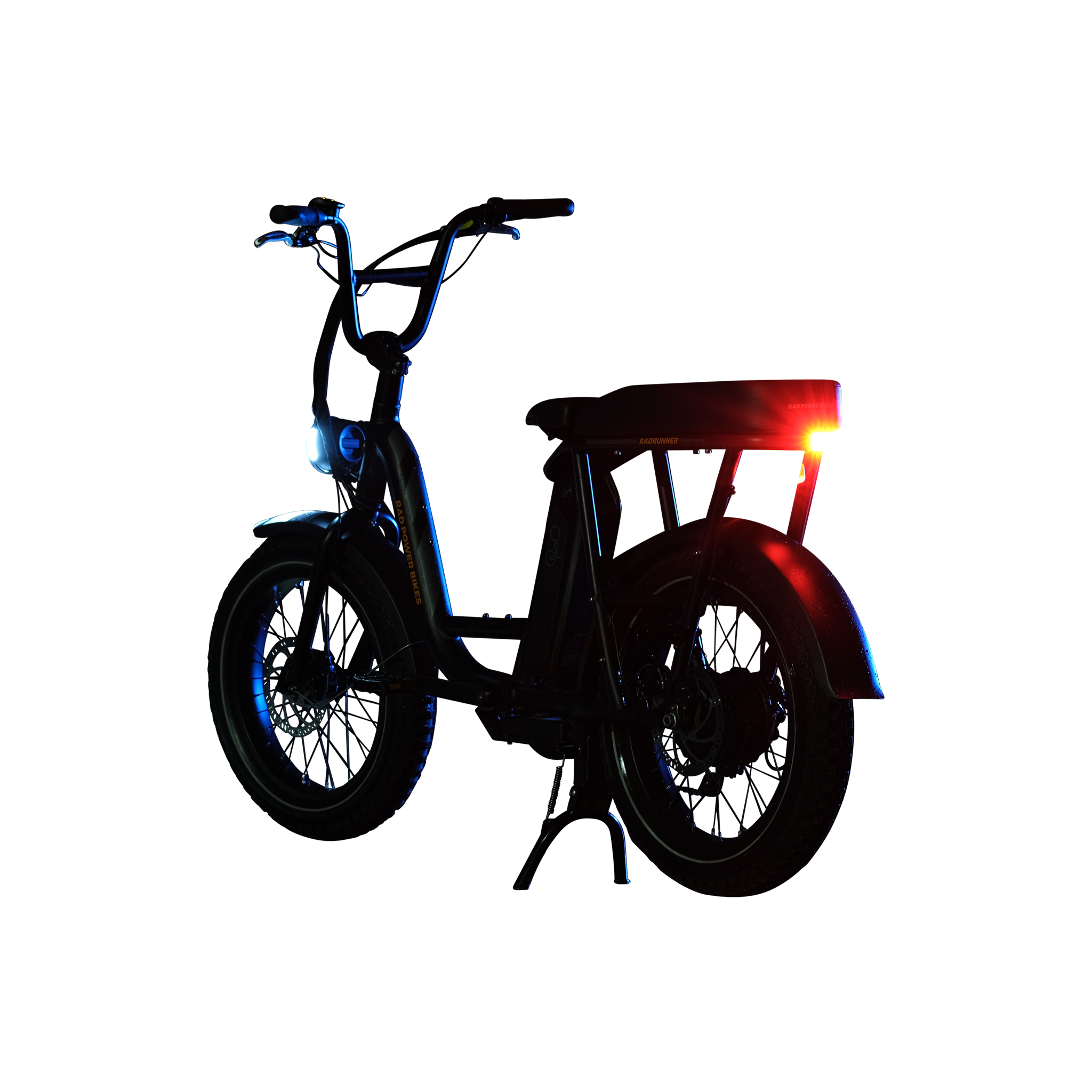 Photo of a Rad Power Bikes RadRunner electric cargo bike with passenger package and Rad logo taillight turned on and mounted below rear seat on the rack.