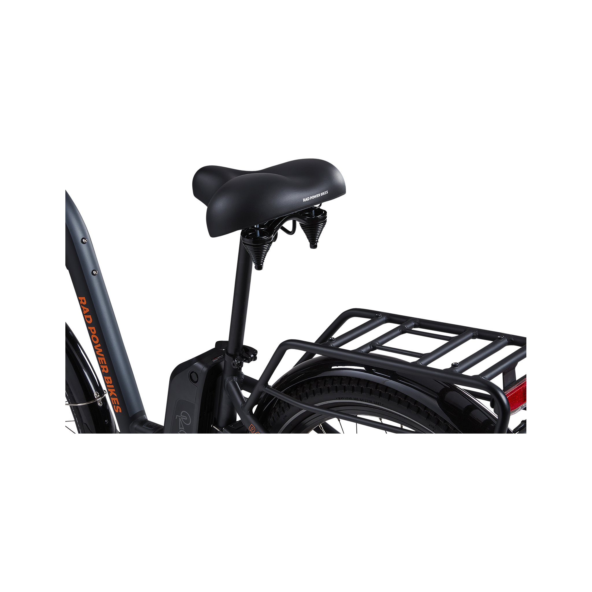 A close-up view of a grey Rad Power bike showing the side and rear of a matte black Enhanced Comfort Saddle, including the springs below the rear of the saddle