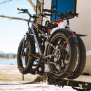Lifestyle photo of a man removing one of two ebikes from a RV Rider Rack mounted on an RV