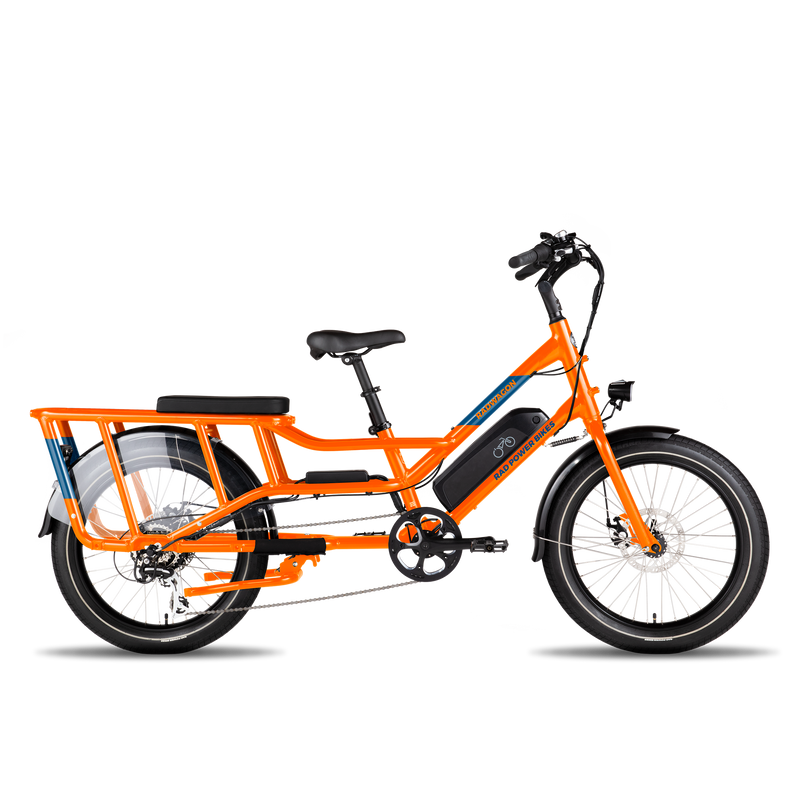 A side profile view of an orange RadWagon, with a black Deckpad cushion mounted on the rear rack