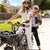 Two women sitting on a RadRunner 3 Plus electric utility bike with accessories installed, including a console and front basket.