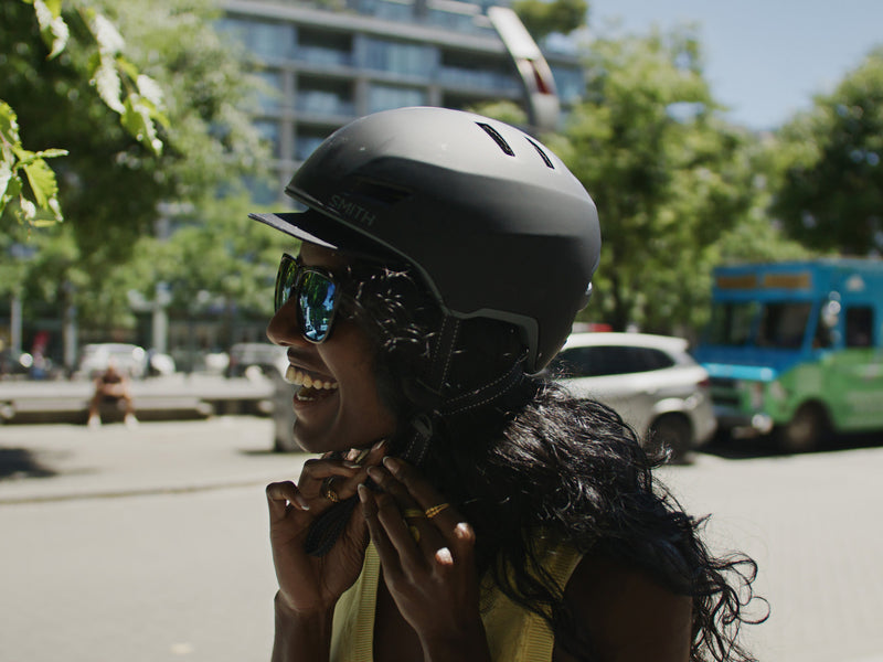 A person wearing sunglasses and a black Smith Express MIPS helmet