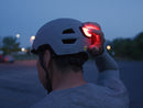 A person turns on the safety light on the back of a cloudgrey Smith Express MIPS helmet